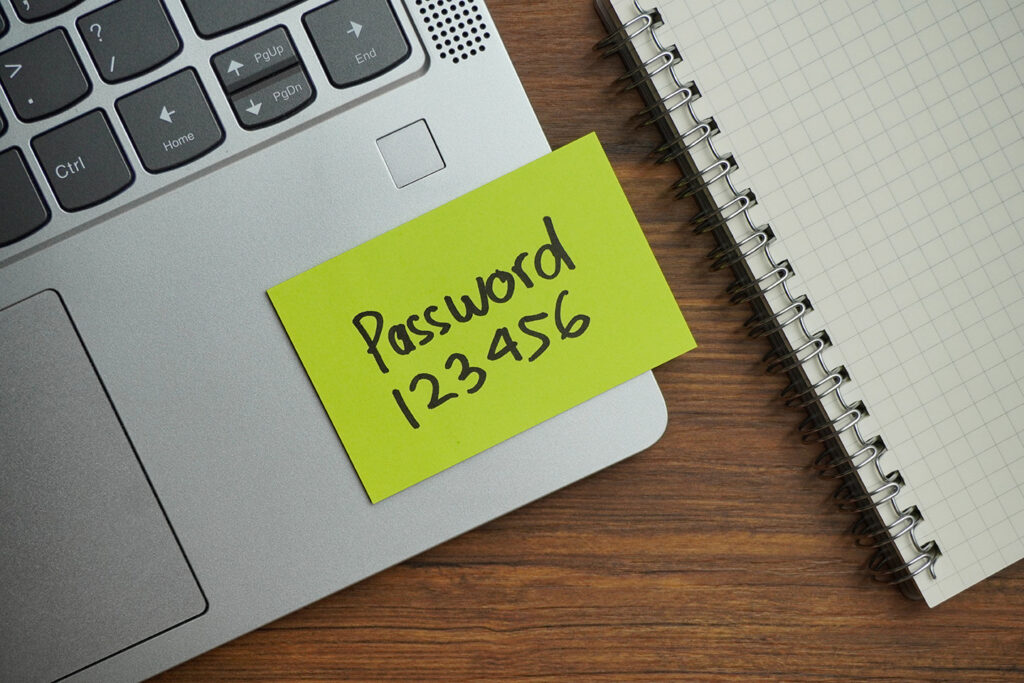 Zettel mit einfachem Passwort auf dem Laptop